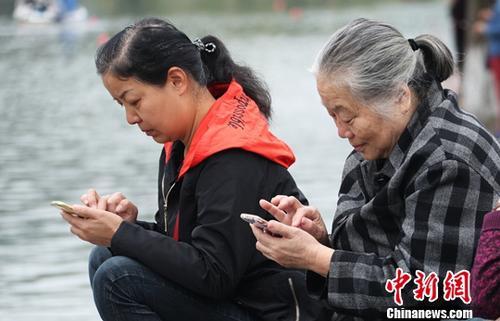 图为中国中老年女性使用智能手机上网。(资料图) 刘占昆 摄